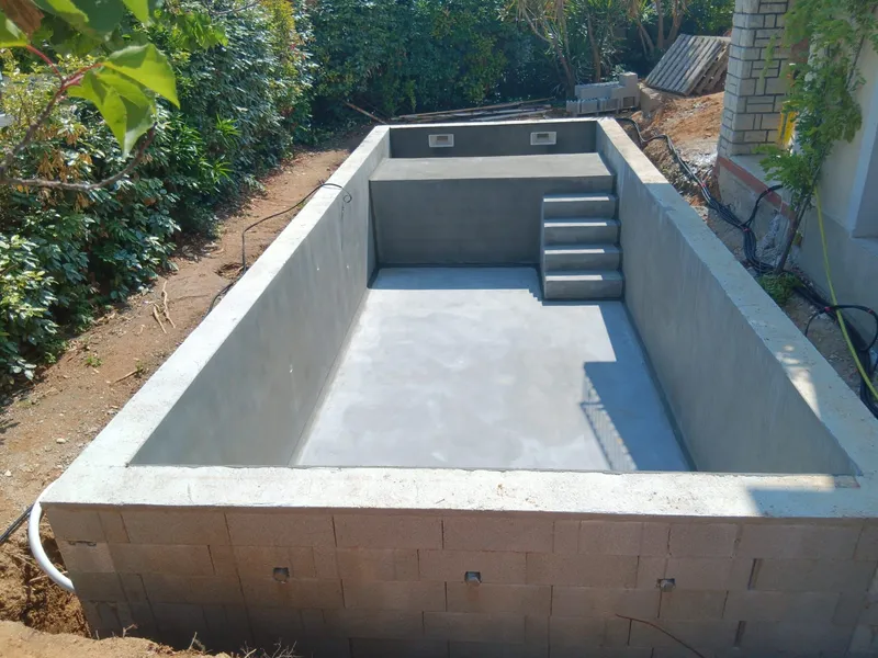 Piscine maçonnée avec escalier. Bassin rectangulaire en cours de construction avec escalier intégré.